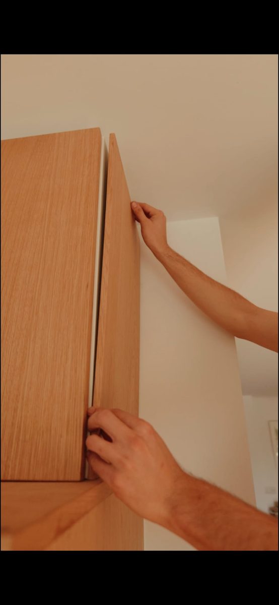 Installer aligning a real wood front to an IKEA cabinet